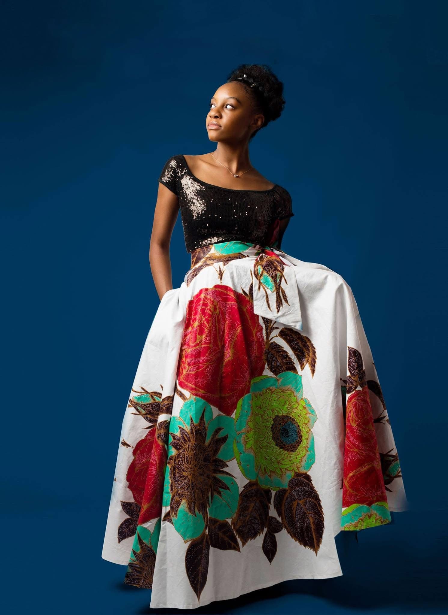 Model wearing a floral Hartbrooks full skirt against a deep blue background